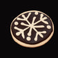 Sugar cookie with white snowflake design on a dark background. Baked by the kitchen at Nystrom Orchard in Worthington Minnesota.