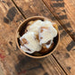 Cinnamon sugar soft pretzel bites with cream cheese frosting on top in a cup on a wooden surface. Baked in the kitchen of Nystrom Orchard in Worthington Minnesota.