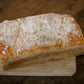 Loaf of sourdough sandwich bread baked in a rectangle pan on a wooden cutting board. Baked in the kitchen at Nystrom Orchard in Worthington Minnesota.