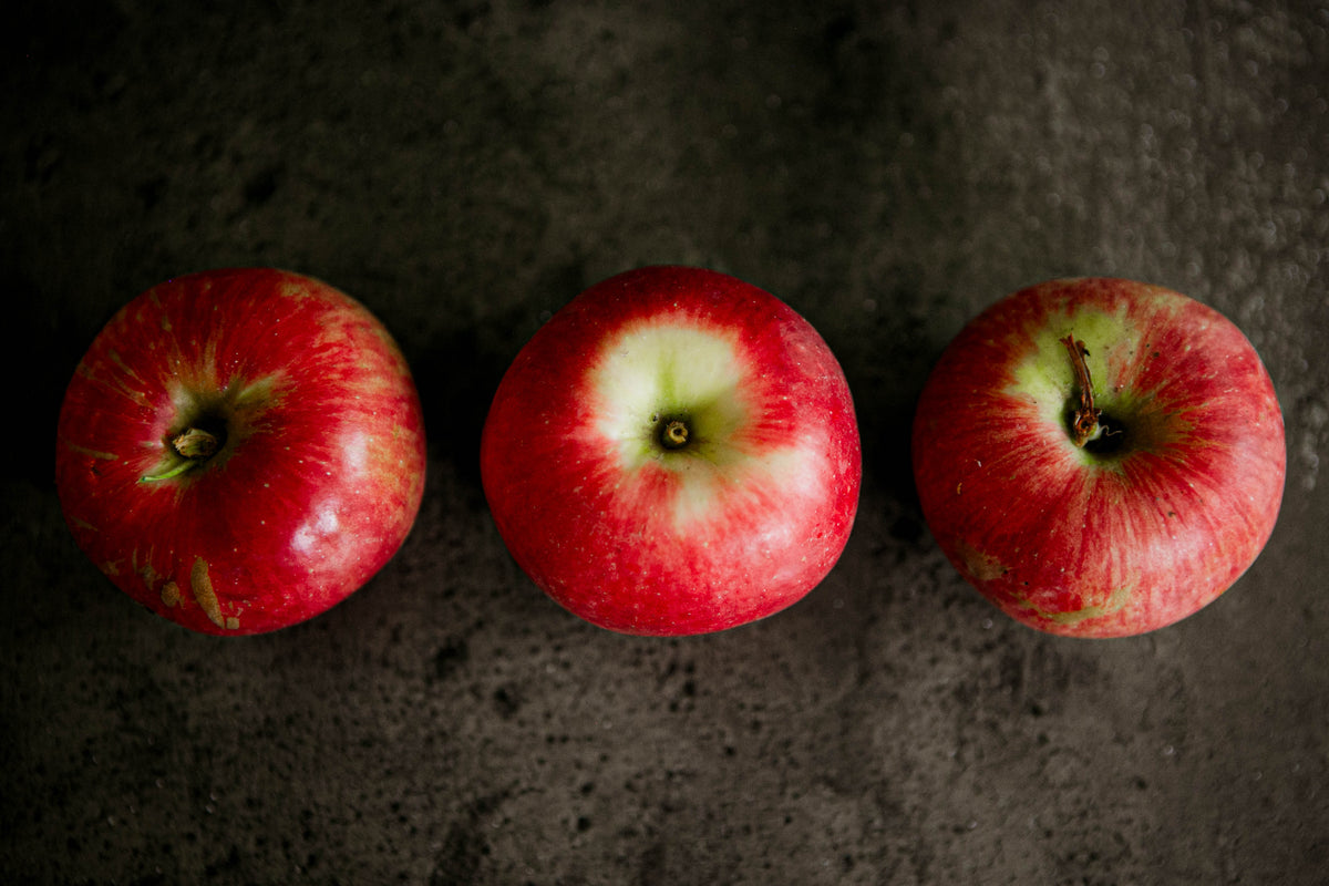 3 State Fair Apples in a row on a black surface. Picked in Nystrom Orchard in Worthington Minnesota.