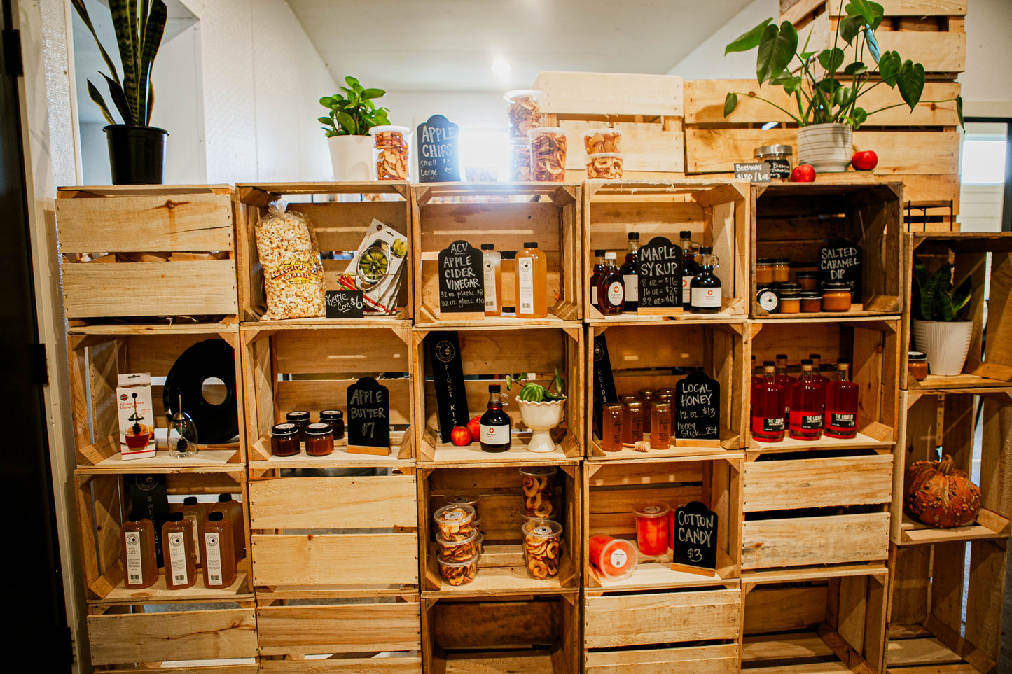 Apple crates stacked to make a wall and shelves with Nystrom Orchard store products and plants. In the store of Nystrom Orchard in Worthington Minnesota.