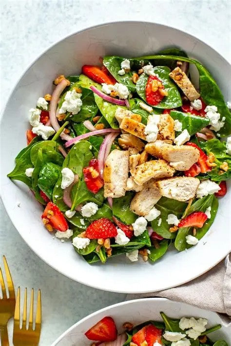 A hearty spinach salad that is topped with chicken, bacon, strawberry, and a house made dressing. It's a hearty lunch or a light dinner option that is easy to grab and eat on the goal. Made by Nystrom Orchard in Worthington Minnesota.