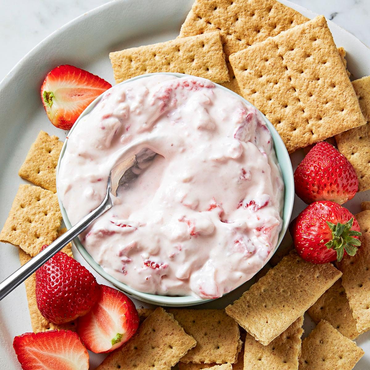 Strawberry cream cheese dip with strawberries and graham crackers on a plate. Made in the kitchen at Nystrom Orchard in Worthington Minnesota.