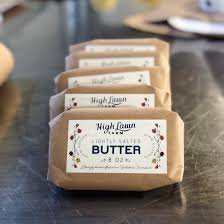 Several packages of butter wrapped in brown paper on a metal table. Created in the kitchen of Nystrom Orchard in Worthington Minnesota.