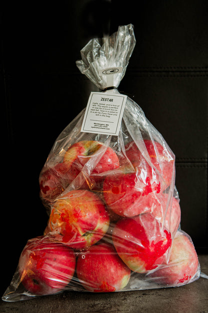 5 lb clear plastic bag of zestar apples with a tag on a black background. Picked in Nystrom Orchard in Worthington Minnesota.