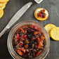 Jar of bacon jam with crackers and cream cheese on a dark surface. Made in the kitchen at Nystrom Orchard in Worthington Minnesota. 