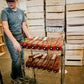 Person pushing a cart full of cold pressed cider ready to stock shelves in a room full of apple crates. Sold in the store of Nystrom Orchard in Worthington Minnesota.