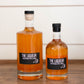 Two glass bottles of apple liqueur on a wooden table with a white background. Made in the kitchen of Nystrom Orchard in Worthington Minnesota. 