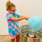 Girl making cotton candy with a machine with white walls in the background. Made in the kitchen of Nystrom Orchard in Worthington Minnesota.