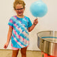 Girl holding cotton candy standing beside a cotton candy machine with a white background. Made in the kitchen of Nystrom Orchard in Worthington Minnesota.